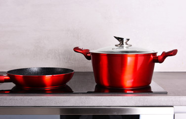 Frying pan and steel pot on modern induction cooktop