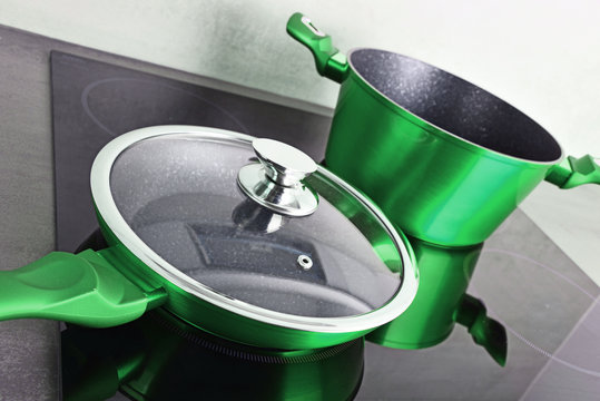 Frying pan and steel pot on modern induction cooktop