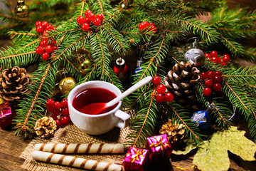 rowan tea in a white cup and cookies - tubes. fir branches with rowan. New Year's and Christmas decorations.