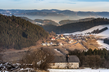 traditional farmhouse and village on sunny winter day