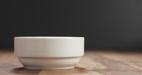 Obraz na płótnie Canvas closeup of white bowl on wood table
