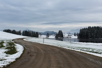 Kurvige Straße durch das winterliche Voralpenland, Allgäu