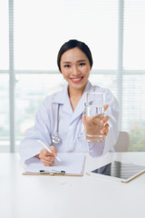 Asian attractive young woman doctor giving young glass of water
