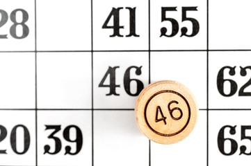 Macrophotography lotto's wooden barrel on paper lotto card. Top view.