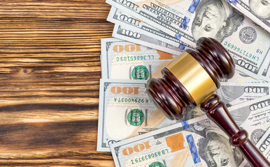 Judge's gavel with dollar bills on the table. Top view.