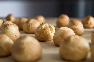French dessert profiterole cake or eclair are on the baking paper