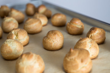 French dessert profiterole cake or eclair are on the baking paper