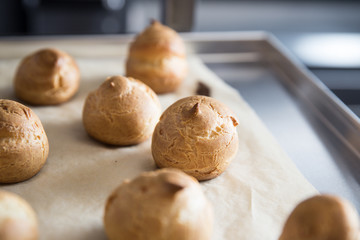 French dessert profiterole cake or eclair are on the baking paper