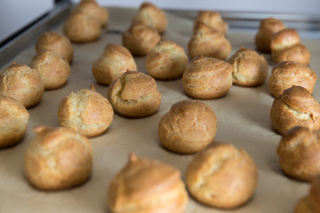 French dessert profiterole cake or eclair are on the baking paper