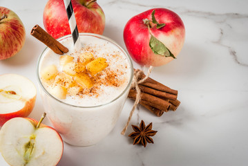 Healthy vegan food. Dietary breakfast or snack. Apple pie smoothies, with apples, yogurt, cinnamon, spices, walnuts. In a glass, on a white marble table. Copy space
