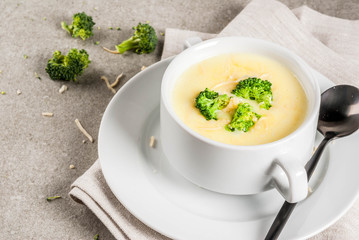 Broccoli, cheese and chicken soup, on gray stone table, copy space