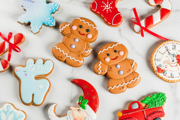 Fototapeta na wymiar Christmas background wit selection of homemade colorful gingerbread cookies. Top view, copy space, white marble table
