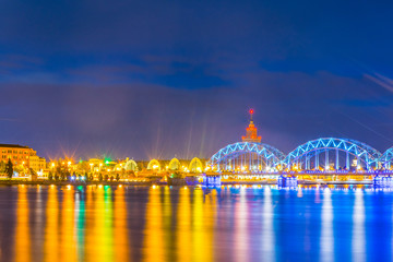 Night view of the zeppelin hangars and the academy of sciences building next to a steel railway bridge in the Latvian capital Riga. © dudlajzov