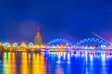 Night view of the zeppelin hangars and the academy of sciences building next to a steel railway bridge in the Latvian capital Riga. © dudlajzov