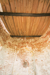 Obraz na płótnie Canvas Old brick cellar with round wooden door of the hatch, inside view