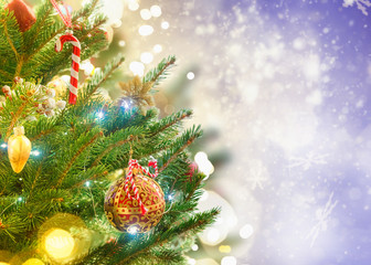 christmas evergreen fresh tree with holiday decorations and lights with copy space on magic bokeh background, toned