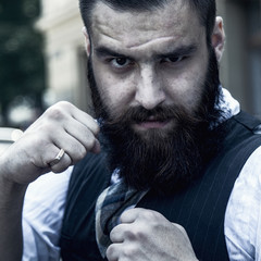 Angry bearded young businessman hipster standing in boxer position and ready to fight