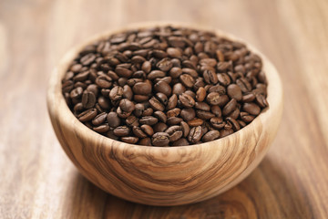 roasted coffee beans in wood bowl on table