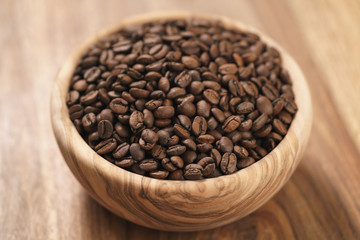 roasted coffee beans in wood bowl on table
