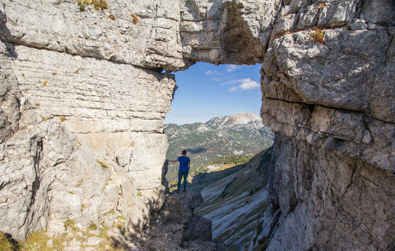 Fototapeta Girl standing in a rock window at Loser mountain, Austria