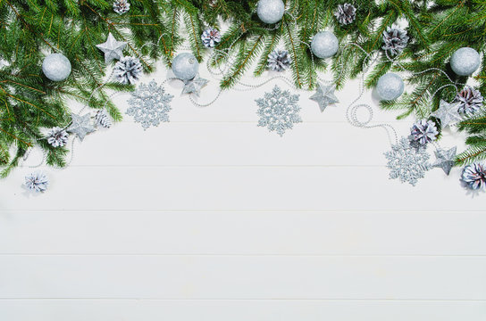 Christmas background frame top view on white wooden plank table background with copy space around products. Decorations isolated on white. Horizontal composition.