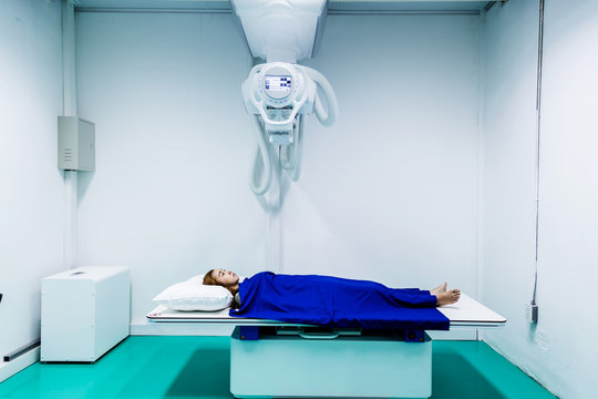 Asian young sick lady sleep on a Scan bed and panel control by Radiologic technician health concept