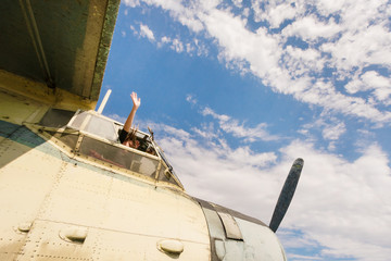 Fototapeta na wymiar Woman in plane cockpit against the sky