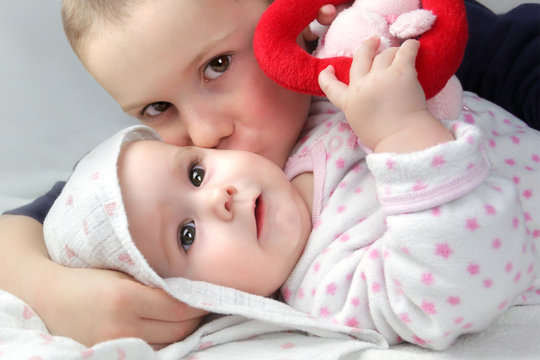 Geschwister: Portrait Junge mit Baby M&auml;dchen und Spielzeug