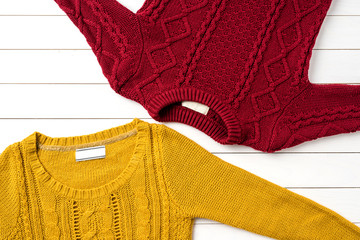 Woman's autumn or winter clothing over white wooden background