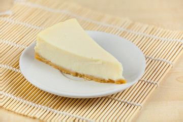 classic cheesecake on white plate on  wooden table