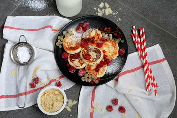 Cottage cheese pancakes with frozen berries and sugar powder with milk