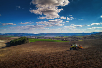 Aerial view of tractors working on the harvest field