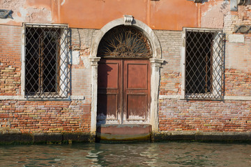 Fototapeta na wymiar Fragment of the façade of the flooded old house. Venice, Italy