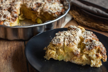 Slice of Homemade Vegan Eggless Whole Apple Cake on Dark Plate Round Baking Form. Wood Table Linen Napkins. Cozy Fall Autumn Atmosphere. Thanksgiving Kinfolk Hygge Slow Living