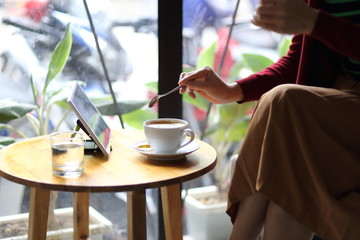 喫茶店でスマートホンを使う女性