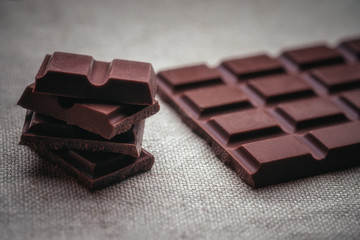 Dark chocolate and background texture of old jute