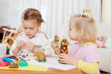 Naklejka premium Preschoolers molding figurines from plasticine .