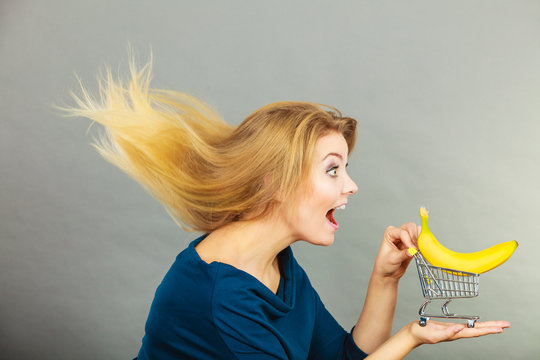 Woman holding shopping cart with banana inside