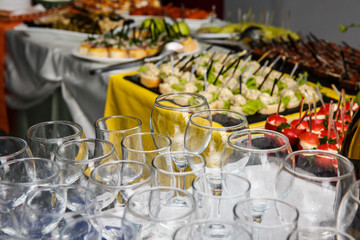 empty glasses stand on a festive table with food preparation for the wedding feast