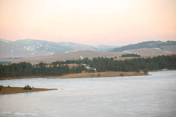 winter landscape, with frozen river and trees.