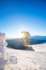 Snowboarding. A man is jumping. Mountain range on the background.