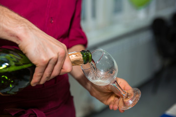 Pouring champagne into glass at hen-party, close up