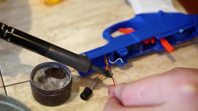 male hand closeup solder 2 wires . Repair of electrical appliances, soldering tin