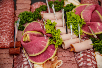Food tray with delicious salami, pieces of sliced ham, sausage, salad - Meat platter with selection