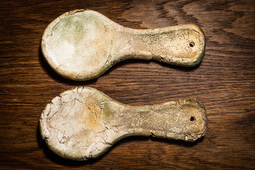 Stylized, old clay rural spoons. Ceramic spoons on a wooden table.