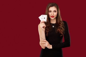 Beautiful caucasian woman in black dress with poker cards gambling in casino
