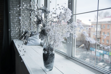 Vase with flower arrangement on the windowsill.