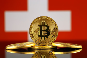 Physical version of Bitcoin (new virtual money) and Switzerland Flag. Conceptual image for investors in cryptocurrency and Blockchain Technology in Switzerland.