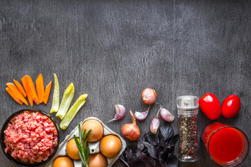 Composition of raw meat with vegetables and spice on wooden background