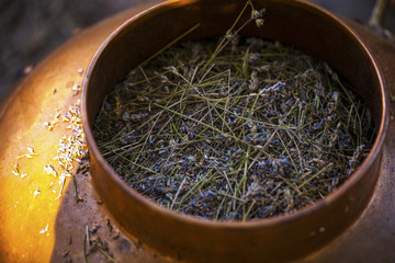 Obraz premium Zabytkowa miska z miedzi używana do destylacji do produkcji olejku eterycznego z lawendy.